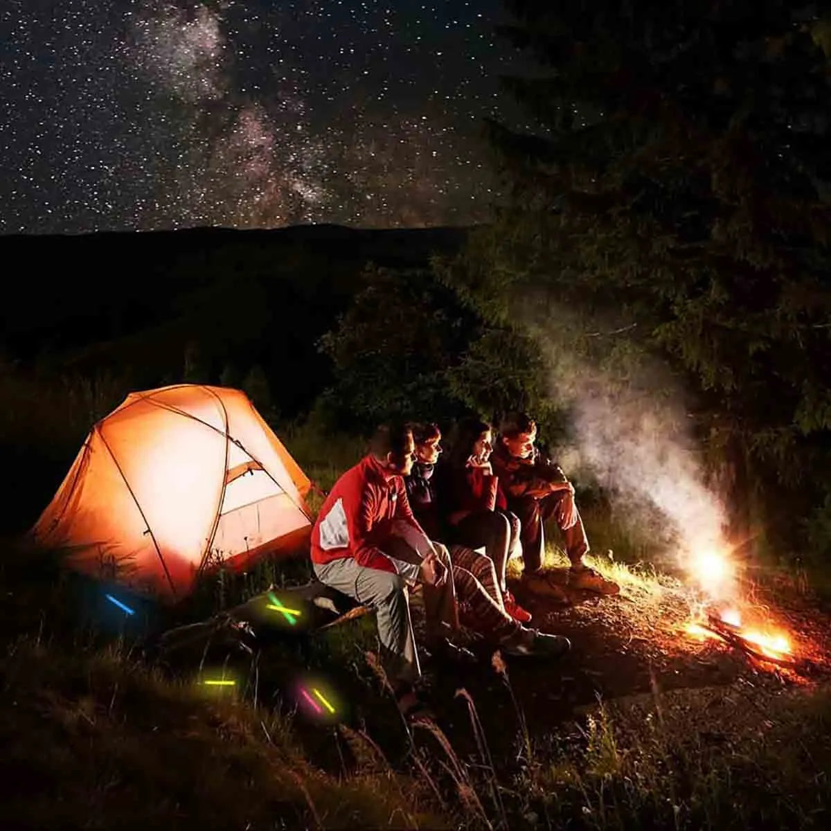 People camping under a starry sky with tent, campfire, and glowing glow sticks – outdoor adventure for kids